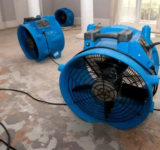 Air movers drying a stripped subfloor after water damage in Matthews, NC